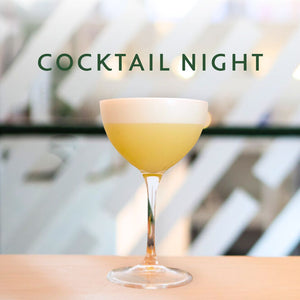 Yellow cocktail in a coupe glass with 'COCKTAIL NIGHT' text above on a blurred background